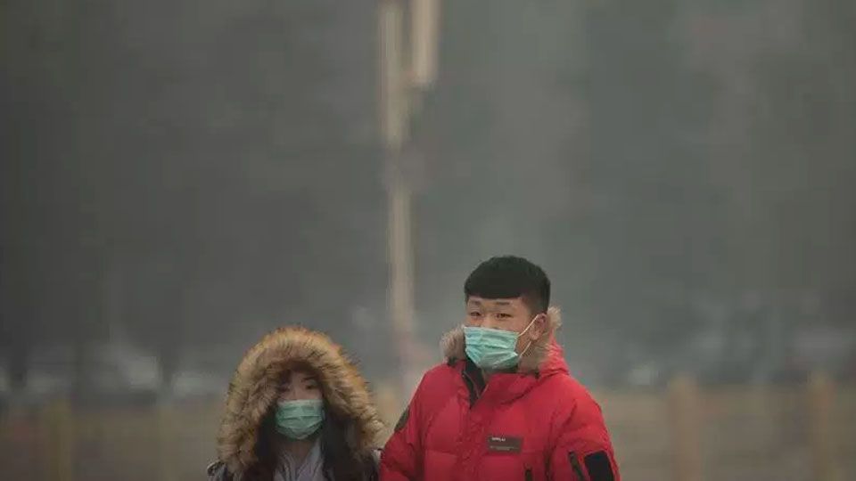 Warga memakai masker menyusul makin parahnya polusi asap yang disebabkan oleh asap pabrik dan kendaraan bermotor. Copyright: © INTERNET/Indian Express